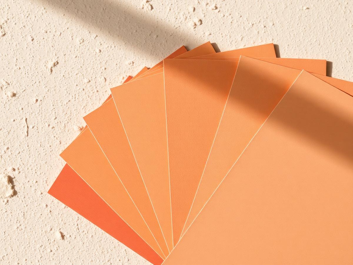 Terracotta paint swatches fanned across a plaster surface